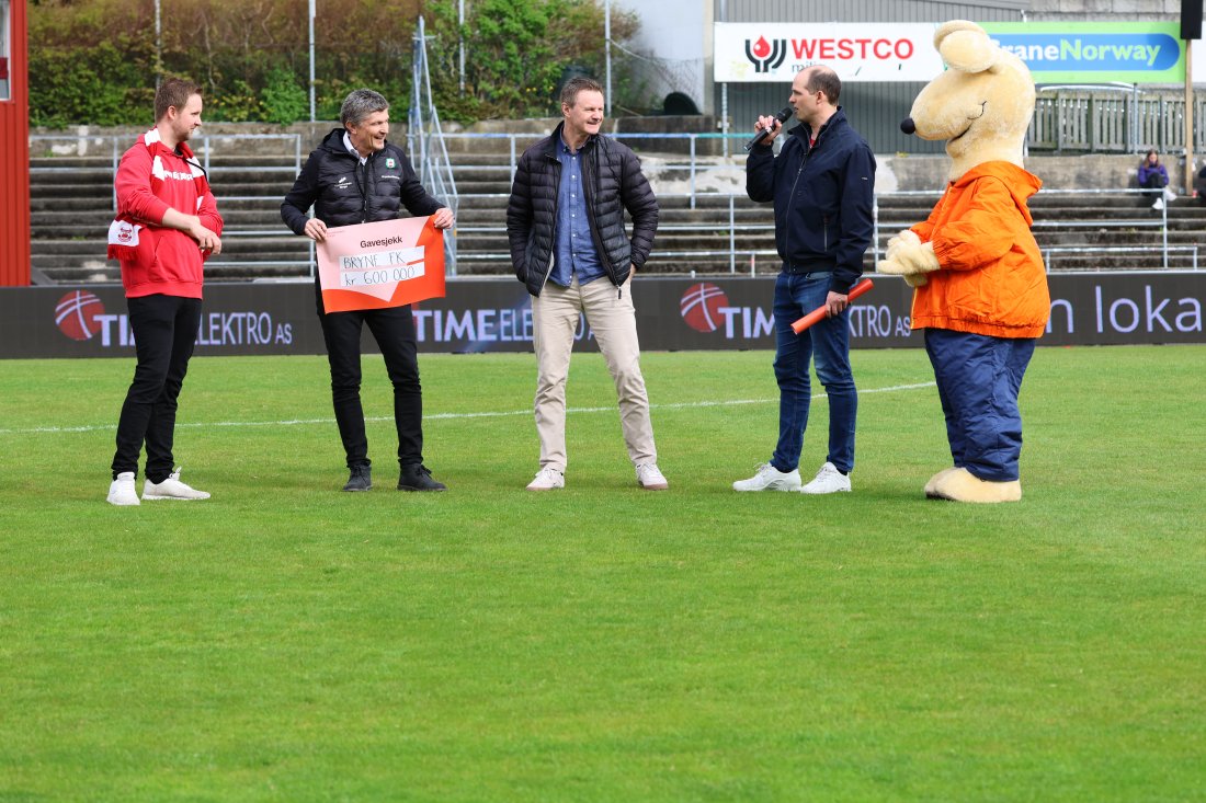 Christoffer Singstad (med mikrofonen) forteller om gavesjekken fra Sparebanken Norge. Morten Seland fra Bondehæren og Hans Øyvind Sagen fra Bryne FK tar gledelig imot sjekkene. Gisle Høyland (i midten) og Gulle var også med fra den engasjerte hovedsponsoren vår.